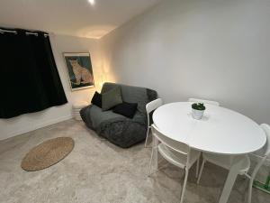 a living room with a white table and a chair at Léopard vert - Clim - Tout inclus in Aubagne +5 photos