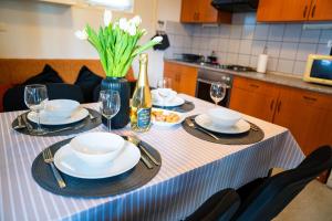 a table with plates and glasses and a bottle of champagne at Hiška 231, 2 karti za Terme 3000, Moravske Toplice in Moravske-Toplice