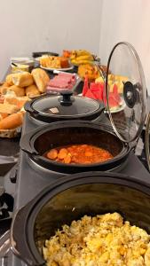 a stove top with many different types of food at Dom Victor Residence Hotel in Goiânia