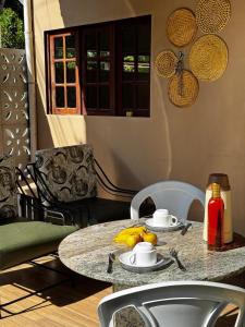 a table with a bowl of fruit on top of it at Casa Aconchego do Mar in Japaratinga