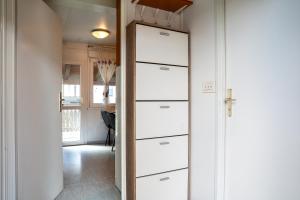 a door leading to a hallway with white drawers at Hiška 231, 2 karti za Terme 3000, Moravske Toplice in Moravske-Toplice