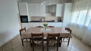 a kitchen with a table with a vase of flowers on it at Meneghin House in San Zenone