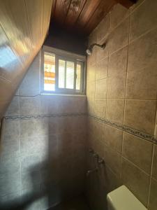 a bathroom with a shower and a toilet and a window at Casa Alpina in Navarro +19 photos
