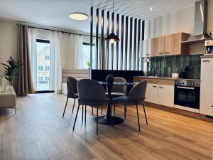 a kitchen with a dining room table and chairs at Schwanstein Apartments Füssen ZENTRUM in Füssen