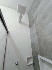 a bathroom with a shower with a light on the wall at Hostel Vila Universitária in Bauru +40 photos