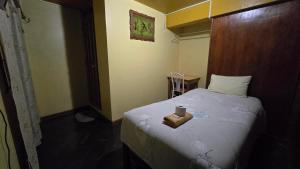 a small bedroom with a bed with a candle on it at Hostal La Casa del Sol in Juliaca