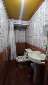 a bathroom with a toilet and a sink at Hostal La Casa del Sol in Juliaca