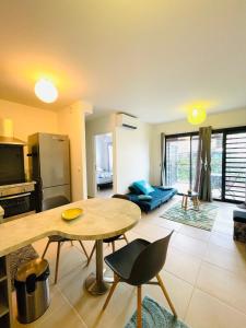 a living room with a table and a kitchen at Heinoa Lodge Papeete in Papeete +8 photos