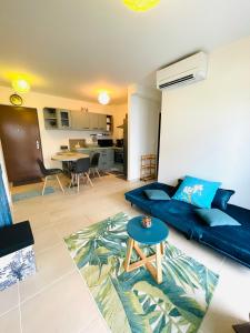 a living room with a blue couch and a table at Heinoa Lodge Papeete in Papeete