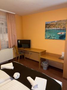 a hotel room with a bed and a desk and a television at Poseidon Hotel in Hirschhorn