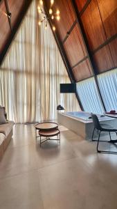 a room with a bed and a couch and a table at Chalé Rio das Pedras - Chalé 03 in Chapecó