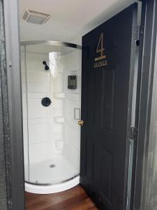 a shower with a glass door in a bathroom at Red River Gorge Creekside Cabin, Hot Tub, Shared Bathhouse in Stanton +12 photos