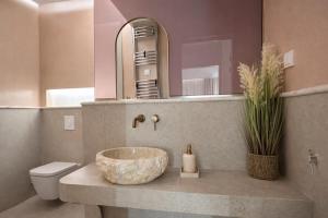 a bathroom with a sink and a toilet and a mirror at NOÈA Luxury Suites in Kavála +20 photos
