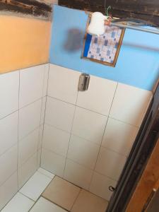 ein Badezimmer mit Dusche und weißen Fliesen in der Unterkunft Starlight Mountain Lodge SIGCHOS in Sigchos + 143 Fotos