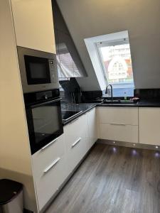 a kitchen with a sink and a microwave at Central Vibe Apartman in Kecskemét