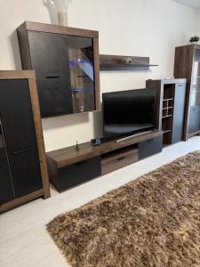 a living room with a large entertainment center with a flat screen tv at Central Vibe Apartman in Kecskemét