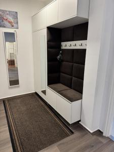 a room with a white closet with a mirror at Central Vibe Apartman in Kecskemét