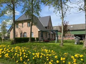 a house with yellow flowers in the yard at Deichhof Knudsen in Oldsum