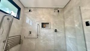 a bathroom with a shower with a glass door at Chalé Rio das Pedras - Chalé 03 in Chapecó
