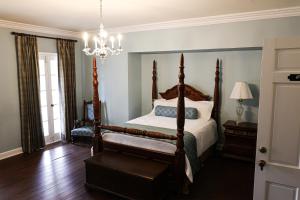 a bedroom with a bed and a chandelier at Ormond Manor in Destrehan