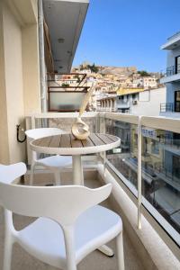 a table and chairs on a balcony with a view at NOÈA Luxury Suites in Kavála