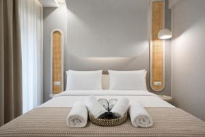 a hotel room with a bed with towels on it at NOÈA Luxury Suites in Kavála