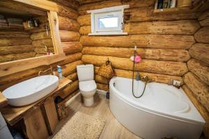 a bathroom with a tub and a toilet and a sink at Vējkalni in Myza Dzirtsiyems +69 photos