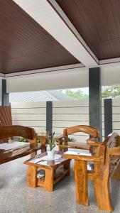 a patio with wooden benches and a table and chairs at Estellie Resthouse in Maya