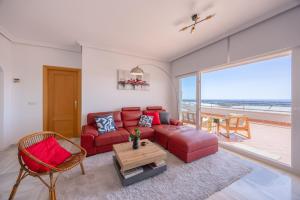 a living room with a red couch and a table at Mediterranean & golf dreams in Alicante