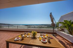 a table on a balcony with a view of the beach at Mediterranean & golf dreams in Alicante