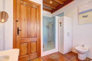a bathroom with a shower and a wooden door at Authentic apartment with pool and sea view in Estepona +25 photos