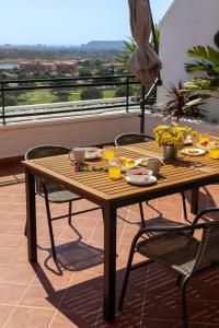 a wooden table with food and drinks on a balcony at Mediterranean & golf dreams in Alicante