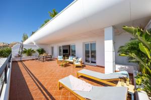 a balcony of a house with chairs and tables at Mediterranean & golf dreams in Alicante