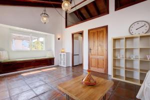 a living room with a table and a clock on the wall at Authentic apartment with pool and sea view in Estepona