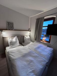 a bedroom with a large white bed with a window at Gästewohnung Mable in Greiz
