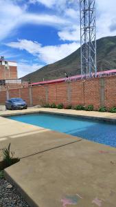 a swimming pool with a car parked next to a brick wall at Hotel Venecia ll in Huánuco