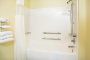 a bathroom with a shower and a shower curtain at Days Inn by Wyndham Lexington NE in Lexington +37 photos