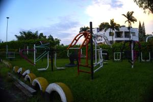 a playground in a grassy field with a slide at Palmeras 2 in Manizales