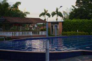 a swimming pool with a gazebo and a building at Palmeras 2 in Manizales