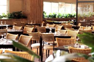 an empty restaurant with tables and chairs at Tauá Hotel & Convention Caeté in Roças Novas