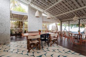 a restaurant with tables and chairs on a patio at Estalagem Caiuia in Japaratinga