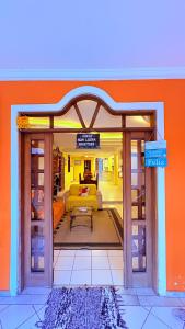 a view of a living room with an orange wall at Terra do Sol Pousada e Hostel in Porto Seguro