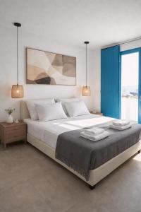 a bedroom with a large bed with two towels on it at Amuse Mykonos Apartments By Vilanel Group in Mikonos