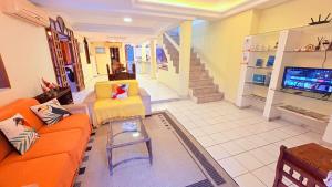 a living room with an orange couch and a tv at Terra do Sol Pousada e Hostel in Porto Seguro +93 photos