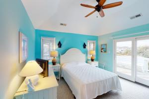 a bedroom with a white bed and a ceiling fan at Seaside Sea Esta in Corolla +44 photos