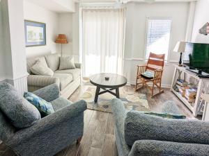 a living room with two couches and a table at Seaside Sea Esta in Corolla