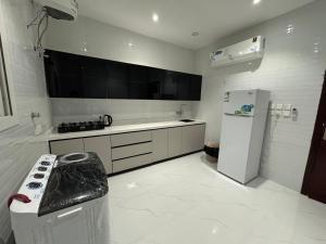 a white kitchen with a stove and a refrigerator at الشقق الفاخرة luxury aparments in Medina
