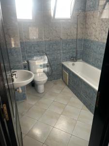 a bathroom with a toilet and a tub and a sink at Appartement Moderne à coté de la plage - Essaouira in Essaouira