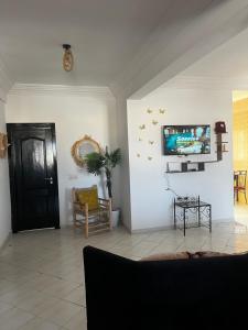 a living room with a tv on a white wall at Appartement Moderne à coté de la plage - Essaouira in Essaouira