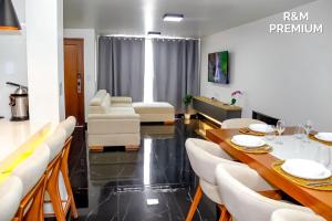 a dining room with a table and white chairs at R&M Premium in Baños